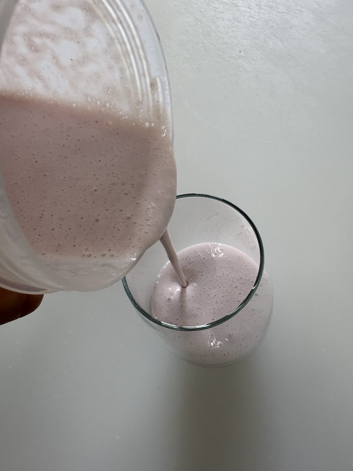 牛乳で割ったベリベリベリーをグラスに注ぐところ